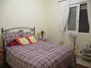 Schlafzimmer mit einem Bett mit bunten Kissen und einem Fenster in der Unterkunft lovely double room with private bathroom in Albox