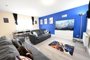 ein Wohnzimmer mit einem Sofa und einem TV in der Unterkunft SPACIOUS 5 BEDROOM HOUSE NEXT TO TOTTENHAM STADIUM in London