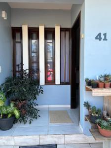 una porta d'ingresso di una casa con piante in vaso di Casa das Suculentas a Jaraguá do Sul