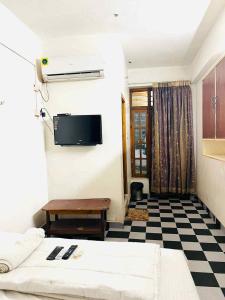 a room with a bed and a tv on the wall at cg residency in Puducherry