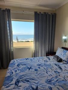 a bedroom with a bed with a view of the ocean at #20 Illovo Views in Kingsburgh