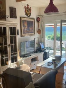 a living room with a tv and a couch and a table at Njegusi-Cetinje in Njeguši