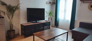Porte de Paris, 4 voyageurs, wifi, Jeux olympiques في فينسين: غرفة معيشة مع تلفزيون بشاشة مسطحة على طاولة