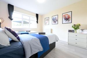 a bedroom with two beds and a window at SPACIOUS 5 BEDROOM HOUSE NEXT TO TOTTENHAM STADIUM in London