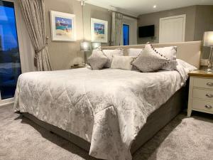 een slaapkamer met een groot bed en een wit dekbed bij Ayrs and Graces - Luxury Bed and Breakfast in Ayr