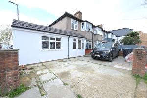 eine weiße Garage mit einem Auto in einer Einfahrt in der Unterkunft SPACIOUS 5 BEDROOM HOUSE NEXT TO TOTTENHAM STADIUM in London