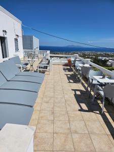 un balcón con mesas y sillas y el océano en Hotel Leta, en Fira