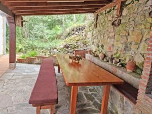 einen Holztisch und eine Bank auf einer Terrasse in der Unterkunft Villa Rural Cantabria in Pechón