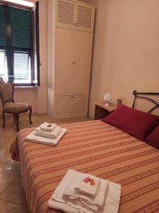 1 dormitorio con 1 cama con toallas en Appartamento Via Rezzano vista mare, en Bonassola