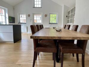 una sala da pranzo con un grande tavolo in legno e sedie di Petite maison privative dans un environnement idyllique a Lasne