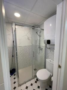 y baño con ducha y aseo. en Aparthotel Pelicano en Benidorm