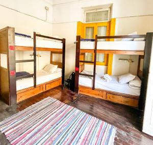 Ithaka Hostel في الإسكندرية: سريرين بطابقين في غرفة مع سجادة