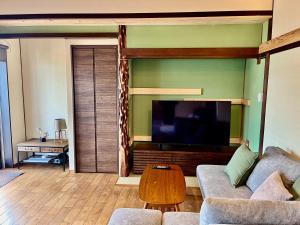 a living room with a couch and a flat screen tv at 海峡別荘 in Shimonoseki