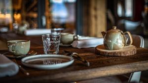 a wooden table with a tea kettle and glasses on it at LA CABANE DU BREUIL in La Bresse