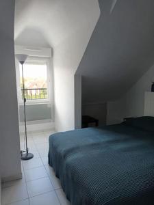 Un dormitorio con una cama azul y una ventana en T2 Cozy Rungis, en Rungis