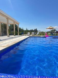 uma grande piscina com água azul em Maison des Oliviers, Yasmine Hammamet, Bouficha em Hammamet Sud