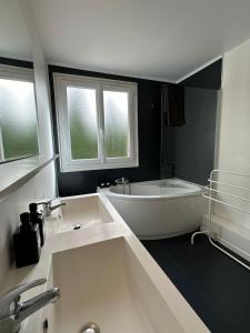 La salle de bains est pourvue d'une baignoire blanche et de 2 fenêtres. dans l'établissement VILLA CONSTANCE 3 Antibes, à Antibes