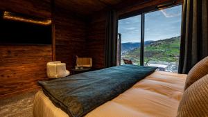a bedroom with a bed with a large window at LA CABANE DU BREUIL in La Bresse +32 photos