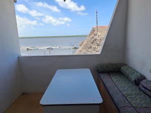 Zimmer mit einem Tisch und Blick auf das Wasser in der Unterkunft Roof Top Private House in Lamu