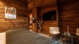 a bedroom with a bed and two chairs and a table at LA CABANE DU BREUIL in La Bresse