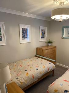 a bedroom with a bed and a dresser at Seaside Modern Apartment in Westward Ho
