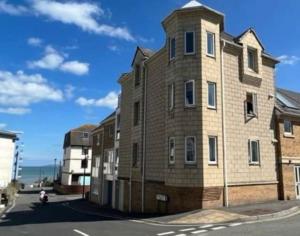 a large brick building on the side of a street at Seaside Modern Apartment in Westward Ho
