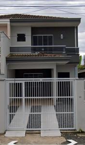 a house with a white gate in front of it at Casaville in Joinville