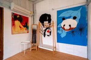 a room with paintings on the wall and a chair at Secret garden pool villa in Hua Hin