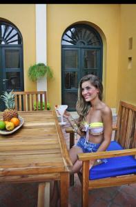 una mujer sentada en una silla en una mesa en Hotel Boutique Castillo Ines Maria, en Cartagena de Indias