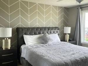 een slaapkamer met een bed en twee nachtkastjes met lampen bij Best home with lake view in Edmonton