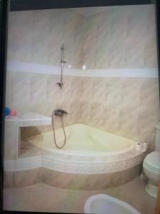 a bathroom with a bath tub and a toilet at Villa Sarah in Ifoutatsene
