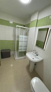 uma casa de banho com um lavatório, um chuveiro e um WC. em Apto a 1 min de la playa em Carboneras