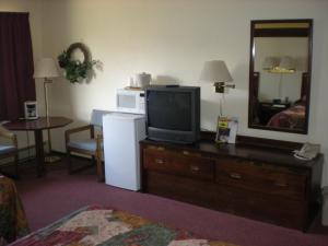 um quarto de hotel com televisão numa cómoda com espelho em American Motel Waseca em Waseca