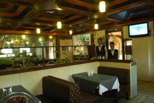 a restaurant with a table and two men in the background at HOTEL GOLDEN PALACE PVT LTD in Mumbai