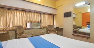 a bedroom with a bed and chairs and a room with a bed and a bed at HOTEL GOLDEN PALACE PVT LTD in Mumbai