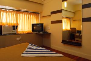 a room with a bed and a tv and a window at HOTEL GOLDEN PALACE PVT LTD in Mumbai