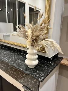 a vase with feathers in it on a counter with a mirror at L'élégant - Coeur de Toulouse in Toulouse