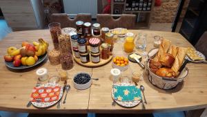 una mesa con un montón de alimentos y bebidas para el desayuno en Ferme des Petites Oreilles 4 étoiles en Montignac