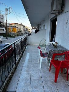 a balcony with a table and chairs on a building at Zozefina apartment in Nea Peramos