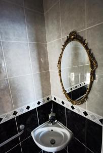 bagno con lavandino e specchio di ANAND HOUSE a Harrow