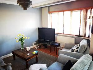 a living room with two couches and a tv at ANAND HOUSE in Harrow