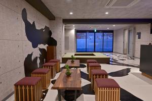 a restaurant with tables and chairs and a mural on the wall at Hotel Tomariya Ueno in Tokyo