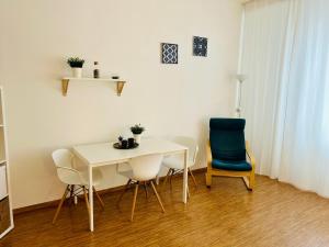 een eetkamer met een witte tafel en stoelen bij Studio Apartment Bluebell in Bratislava