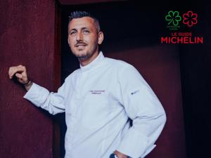 a man in a white chef uniform leaning against a wall at Domaine Riberach - Restaurant étoilé - Spa - Piscine naturelle - Vignoble bio in Bélesta