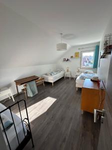 Sala de estar con 2 camas y mesa en Le Cosy Home Annecy, en La Balme-de-Sillingy