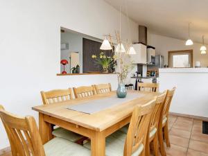 een keuken en eetkamer met een houten tafel en stoelen bij Holiday home Blokhus LXVI in Blokhus