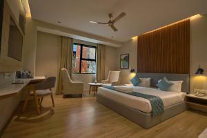 una camera d'albergo con letto e scrivania di Hotel Aurum Keys - ORR Bagmane Tech Park a Bangalore
