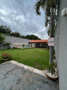 um quintal com uma palmeira e uma casa em Casa Sa Pedra em Aparecida de Goiânia