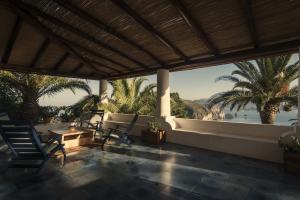a porch with chairs and a view of the ocean at Case Quattrocchi - Giardino e Terrazzi con vista Panoramica sul Mare, Etna e Vulcano in Lipari