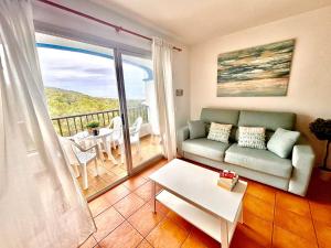 sala de estar con sofá y balcón en Apartamento en Ibiza, en Cala San Vicente